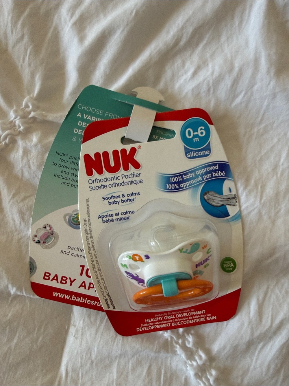 NUK Silicone Orthodontic Pacifier in White with Orange & Teal Accents (0-6m)